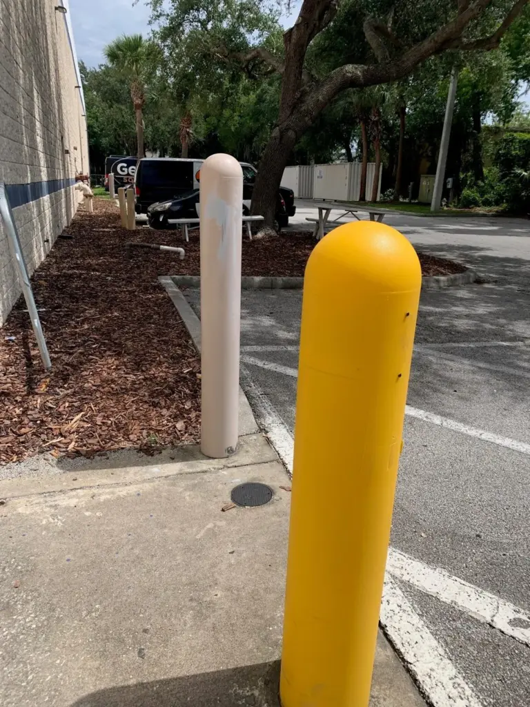 Steel Pipe Bollards 3 Steel bollard with yellow plastic cover sleeve next to a bare post